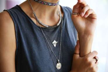 Layered silver necklaces over a dark sleeveless top