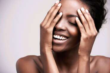 Smiling woman framing her face with her hands