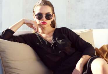 Woman in sunglasses reclining on a sofa