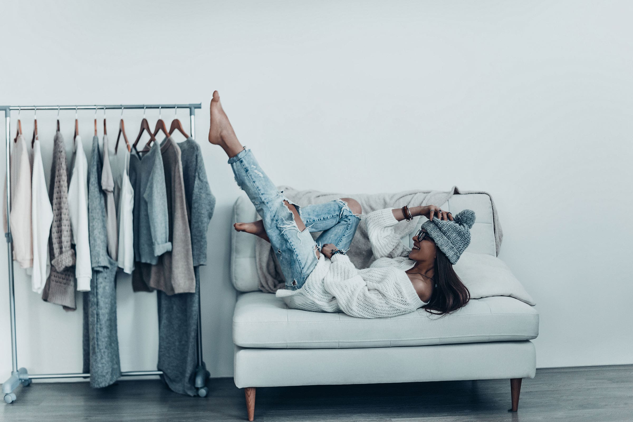 Woman relaxing beside a rail of clothes
